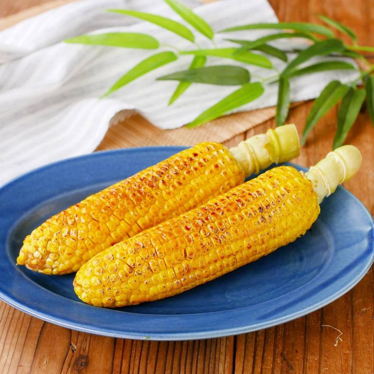 青い皿に乗っている絶品焼きとうもろこし