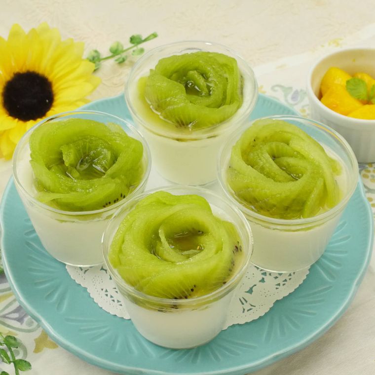 青い丸皿の上に、カップに入ったパンナコッタがおかれている