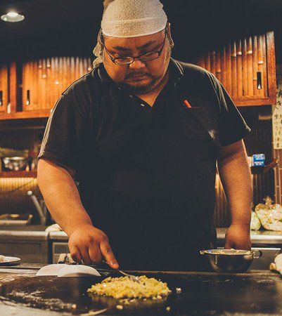 鉄板で焼きそばを焼く男性