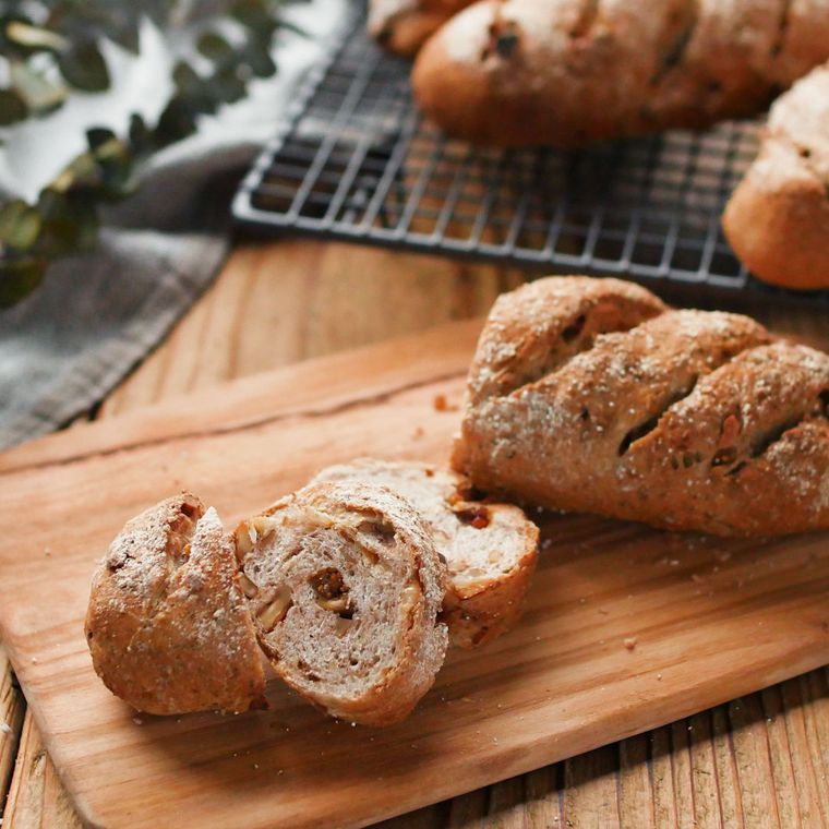 木のまな板の上にくるみといちじくのライ麦パンが置かれている