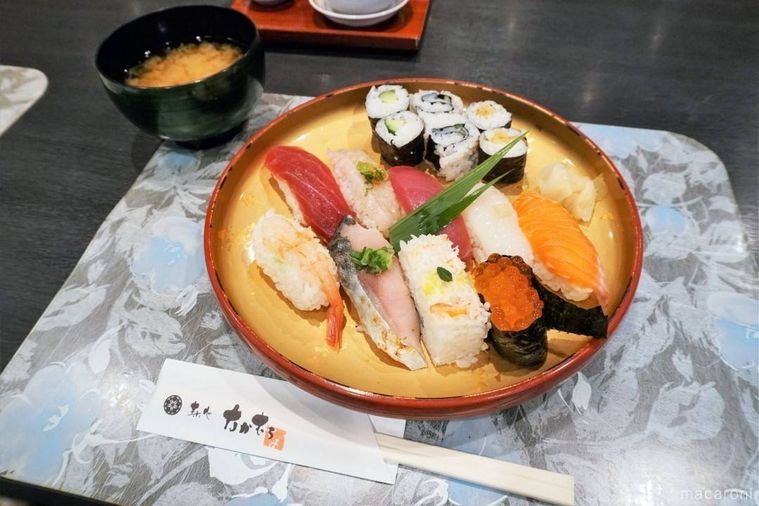 お寿司と巻物、椀物がテーブルに置かれている