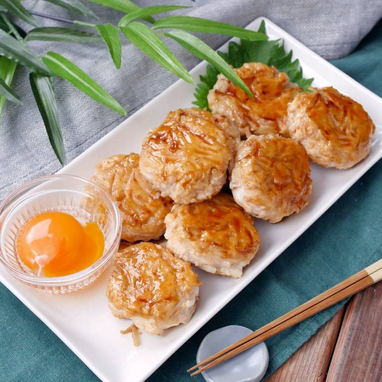 卵黄が添えられた鶏むねもやしの甘辛つくね