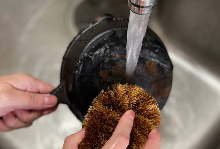 スキレットについたサビをたわしで落としている