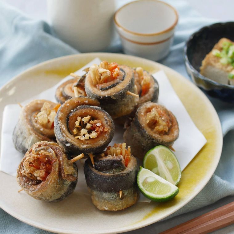 ベージュの丸皿に盛り付けたさんまとごぼうの竜田揚げ