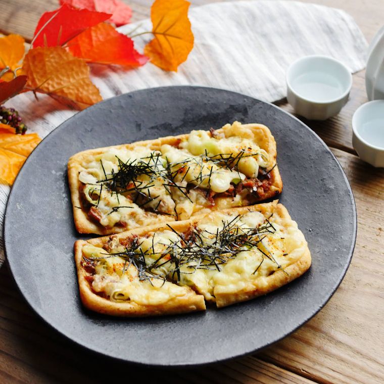 黒いプレートに盛り付けたさんま蒲焼缶詰の和風油揚げピザ