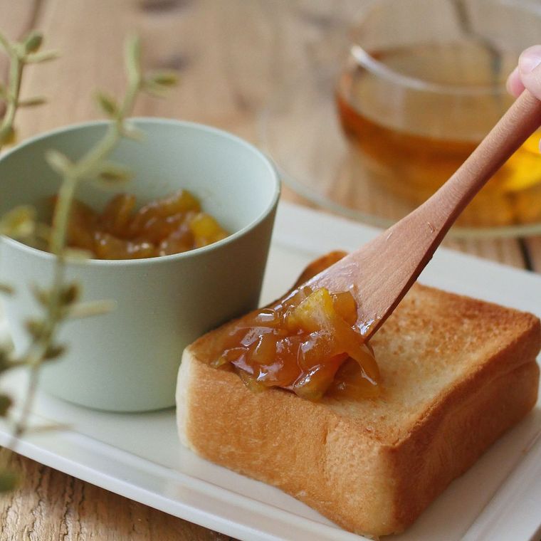 焼き立てのパンにキャラメルりんごジャムをのせている様子