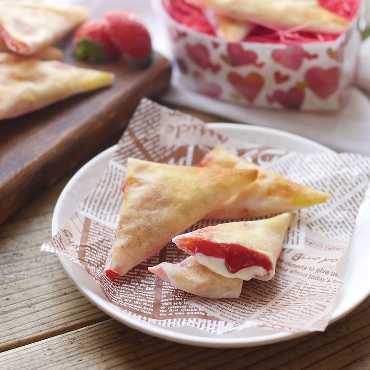 白い皿に盛りつけられた春巻きの皮の三角いちごチョコパイ