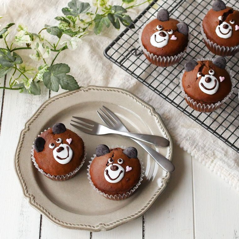 クマの顔が描かれたマフィンがお皿に2個、ケーキクーラーに3つ置かれている
