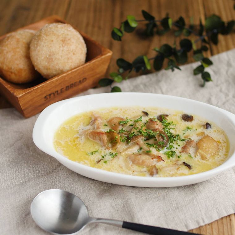 平たいグラタン皿に入ったチキンときのこのクリームスープ