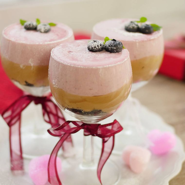 リボンをかけたグラスに入ったかけた、チョコとベリーの3層ムース