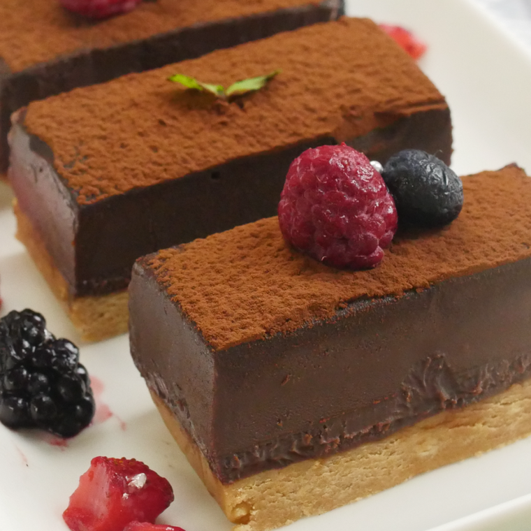 ラズベリーをトッピングした、生チョコタルトがのった白い皿