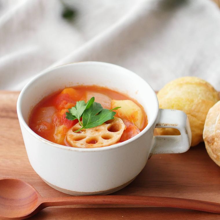 白いスープカップに入れたトマトポトフとパン