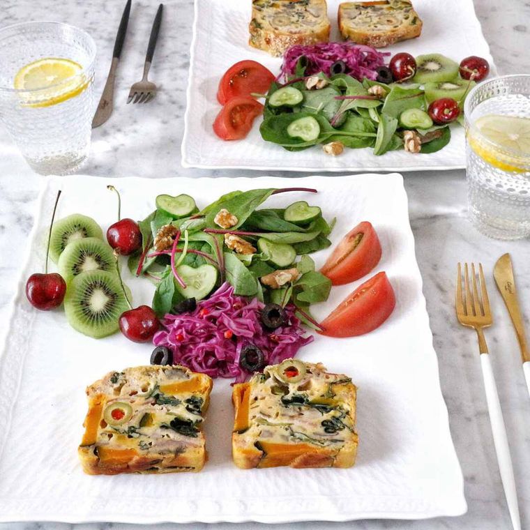 白い皿にサラダと一緒に盛り付けたかぼちゃと舞茸のケークサレ