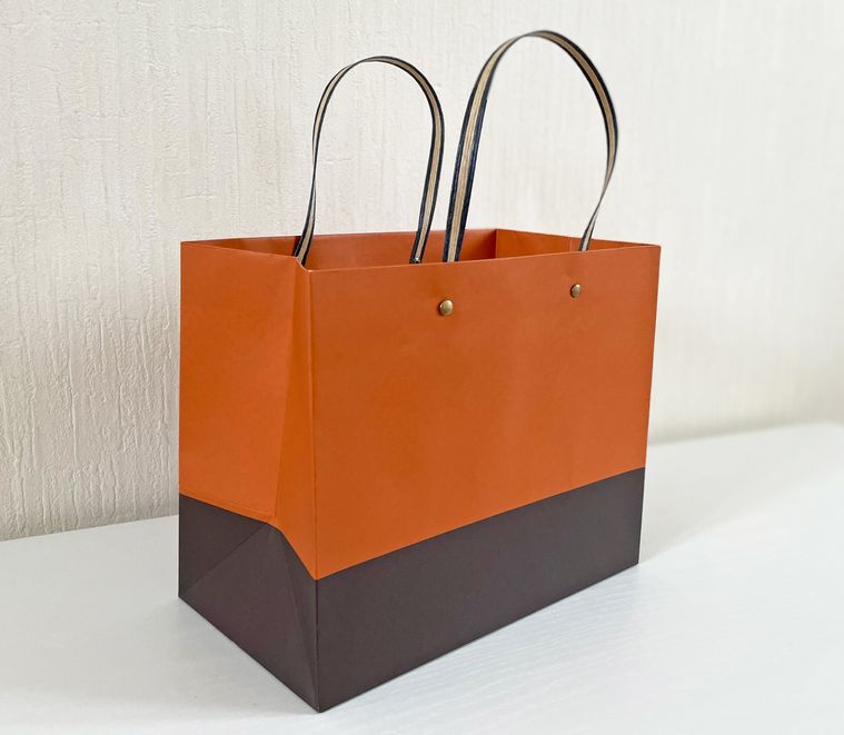 テーブルに置かれたダイソーのバイカラー紙袋オレンジ