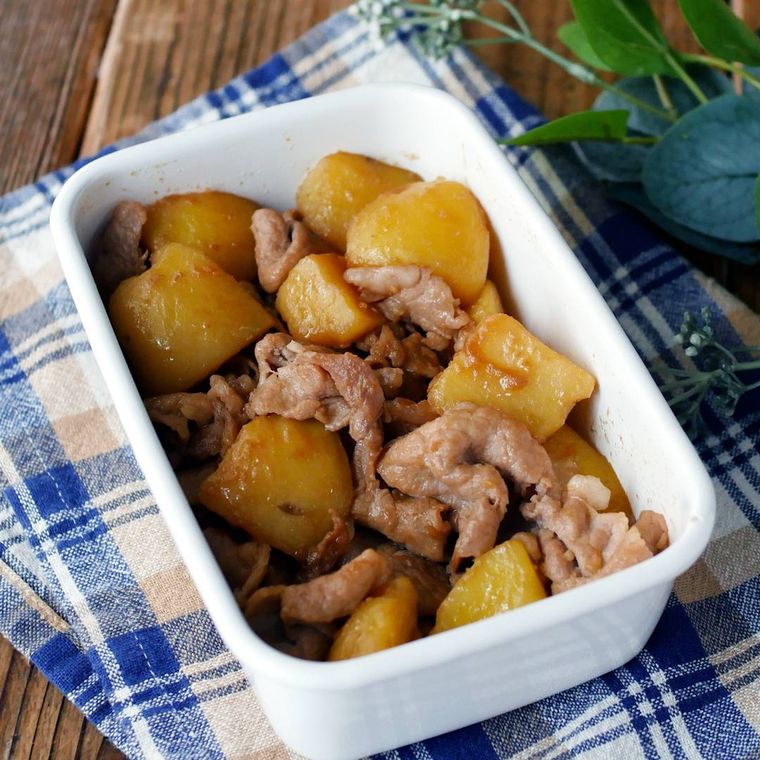 白い容器に入った豚こま肉とじゃがいものガリバタ炒め