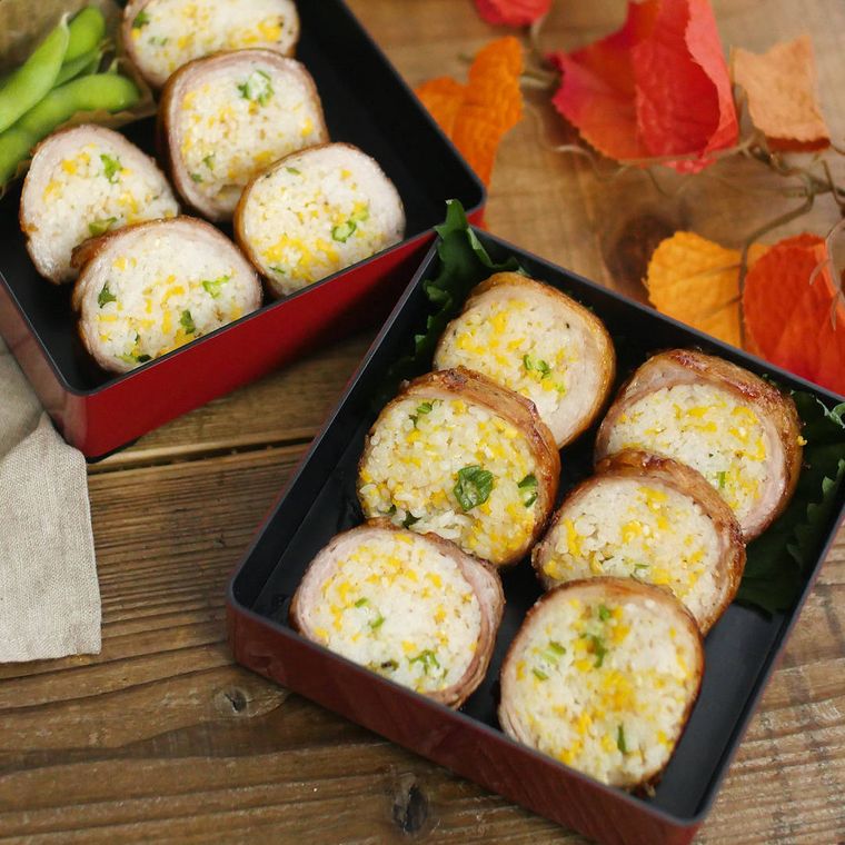 お重箱に並べられているポークロール寿司