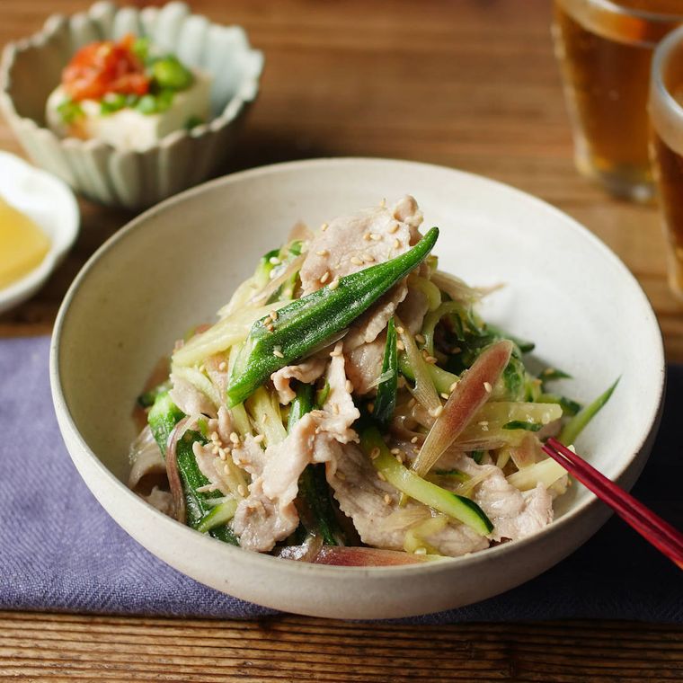 白い丸皿に盛り付けられているオクラと豚肉の和風サラダ