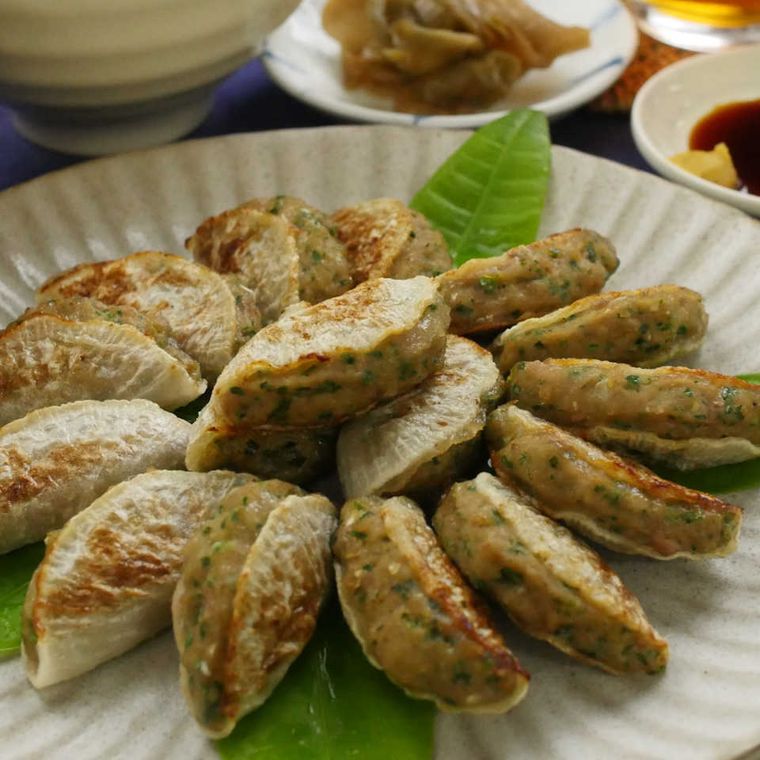 白い丸皿と飾り葉に盛った大根餃子