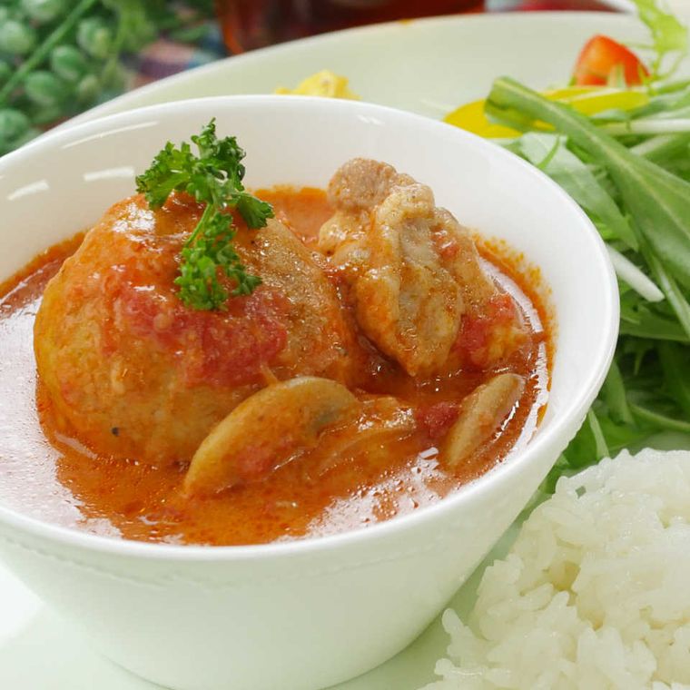 じゃがいもが丸ごと入っているトマト煮込みを盛った器