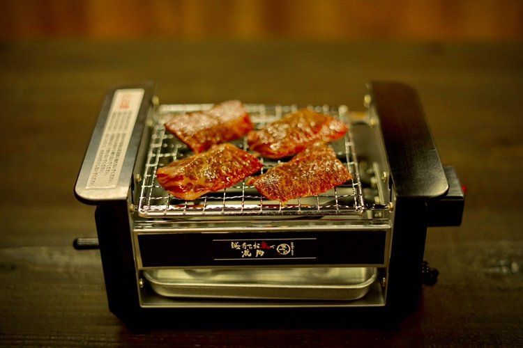 肉を焼いているロースターがテーブルに置かれている