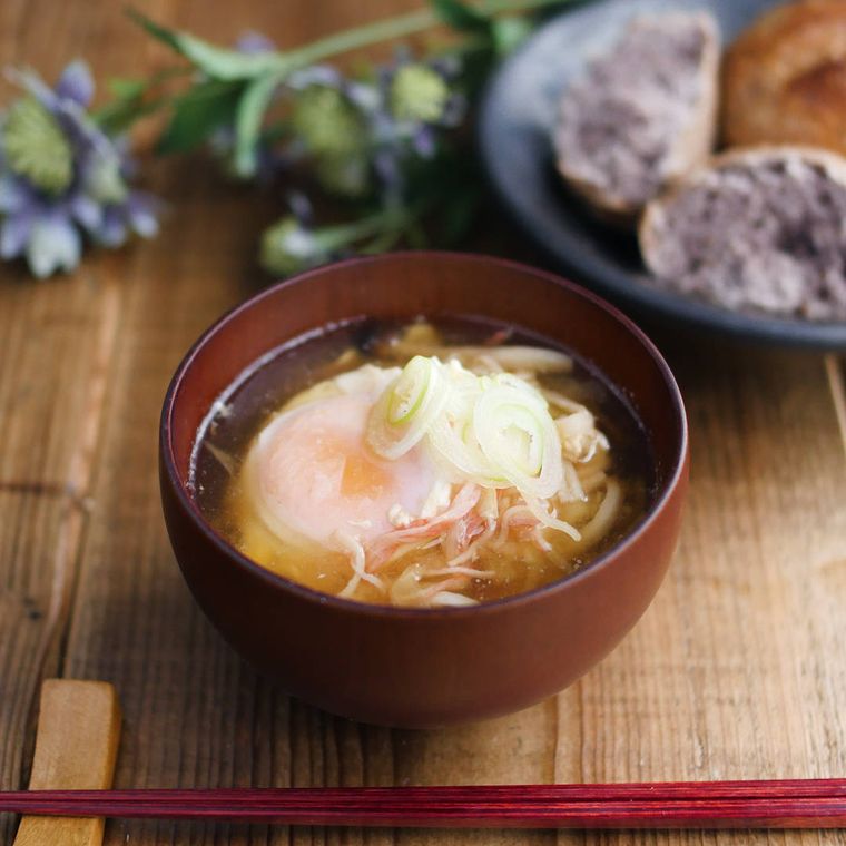 お椀に落とし卵の具だくさんお味噌汁が入っている