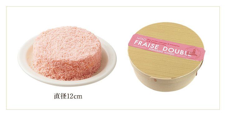 おさらに乗ったピンク色の丸いケーキとケーキの箱が並んで置かれている