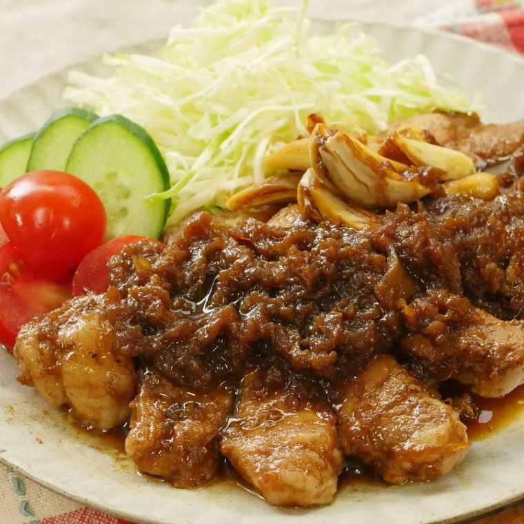 生野菜が添えられた、玉ねぎソースのトンテキ