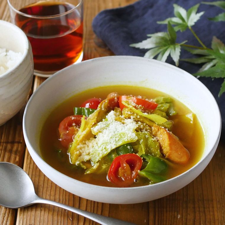 白い器に盛り付けられた野菜とウインナーの和風スープカレーとごはん