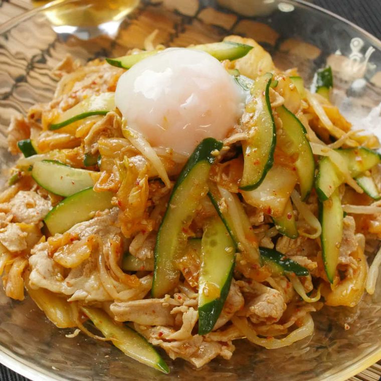 ガラスの丸皿に盛り付けられている豚もやしの温玉のせピリ辛冷しゃぶ