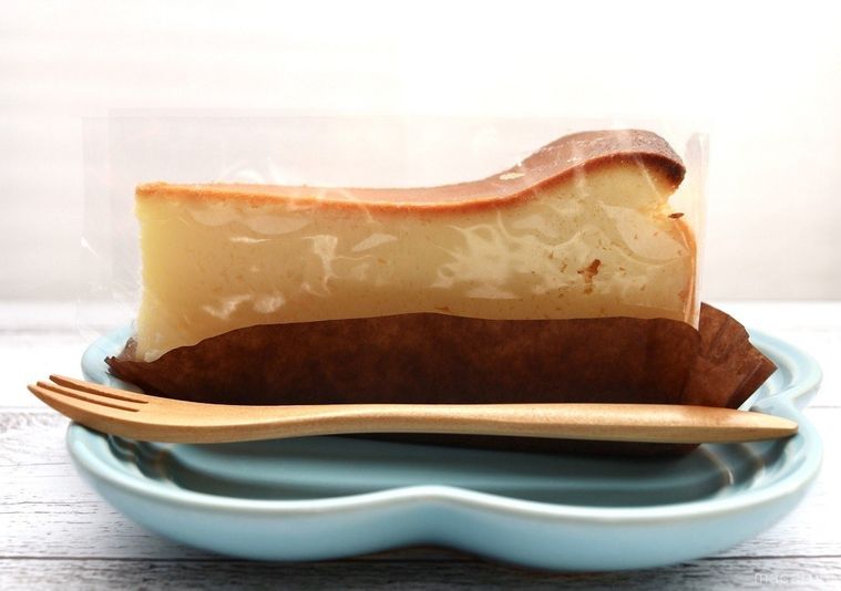 テーブルの上に、お皿にのったニューヨークチーズケーキが置かれている