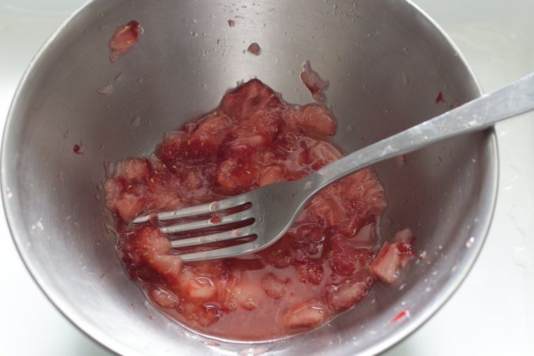 ボウルにいちごが入っていて、フォークの背で潰している