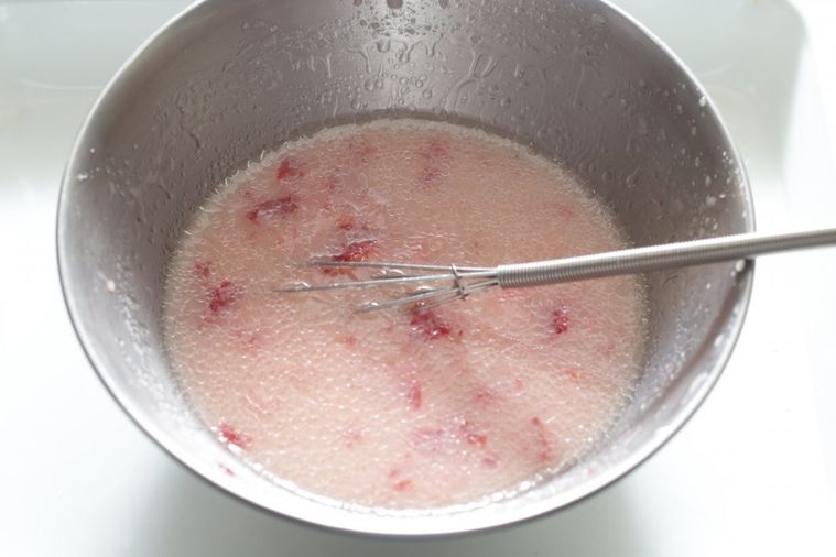 ボウルにいちごと牛乳が入って泡だて器で混ぜている