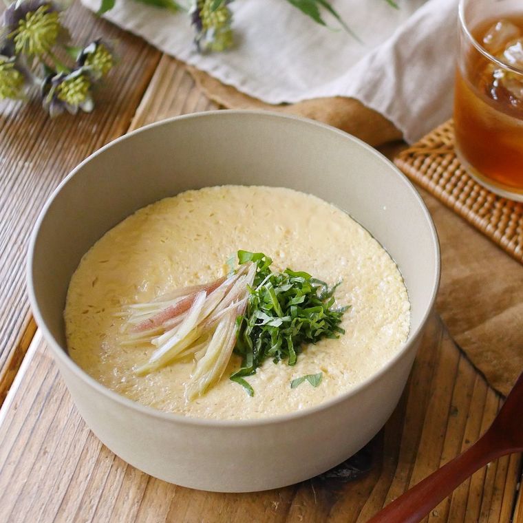 グレーのお椀になめらか豆腐茶碗蒸しが入っており、上にはみょうがと大葉がトッピングされている