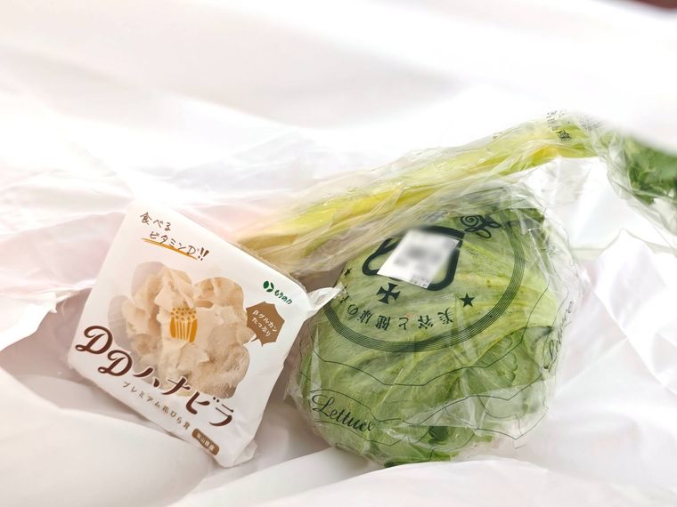 ショルダーになる折りたたみショッピングバッグに野菜を入れている様子