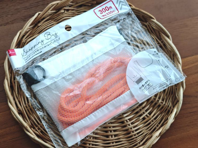 ショルダーになる折りたたみショッピングバッグが机の上に置いてある