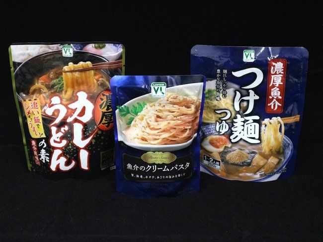 パッケージに入ったレトルトカレー、パスタ、つけ麺が置いてある