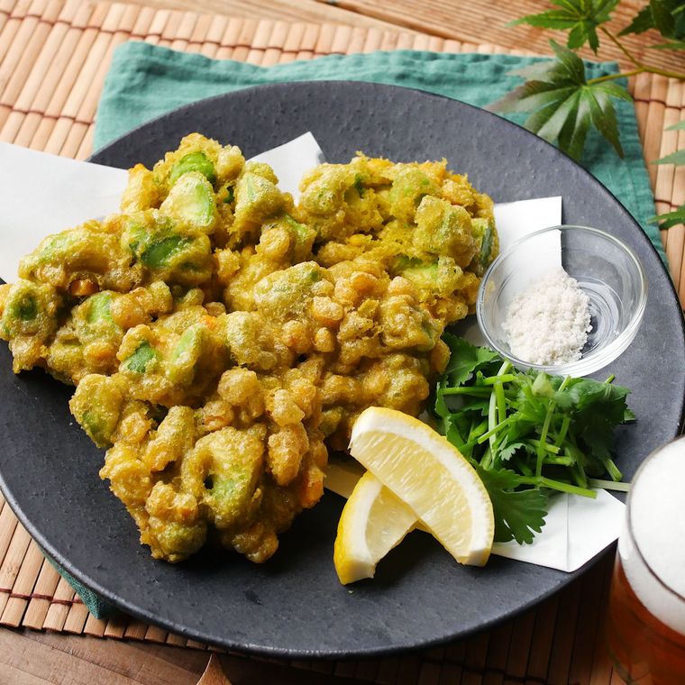 黒い丸皿に盛ったアボカドとコーンのかき揚げ