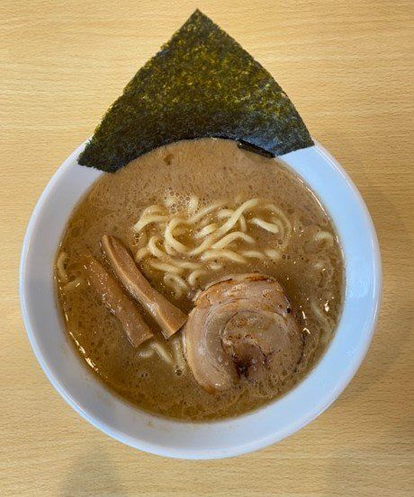 どんぶりの中に海苔とチャーシュー、メンマがのったラーメンが入って置いてある