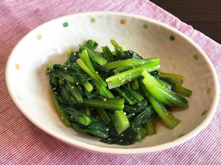 縁に模様が付いた白い皿に盛り付けられた小松菜のナムル