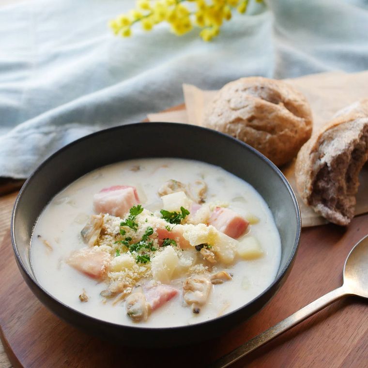 黒い器に盛り付けられたあさりとじゃがいものチャウダー