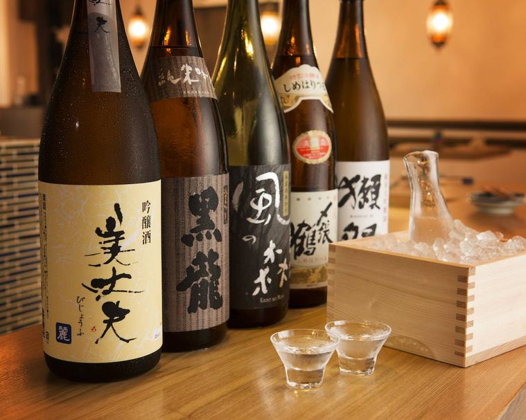 お酒の瓶とお酒が入ったコップが置いてある