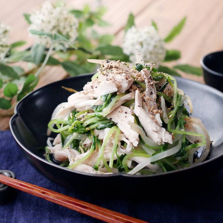 黒い器に盛り付けられた鶏むね豆苗もやしのうま塩ナムル