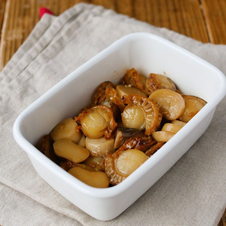 白い保存容器に盛り付けられたエリンギとベビーホタテの甘辛バター炒め