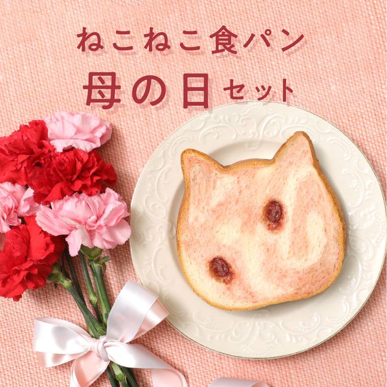 おさらの上にピンク色の猫の形をした食パンがのってカーネーションと一緒にテーブルに置かれている