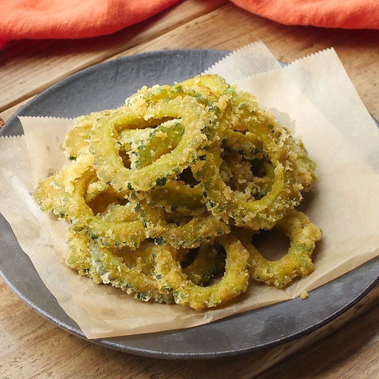 グレー色の皿に盛りつけられている、カレー風味のゴーヤチップス