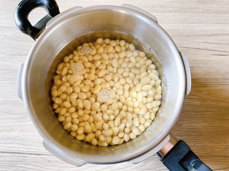 圧力鍋に大豆と水を入れる様子