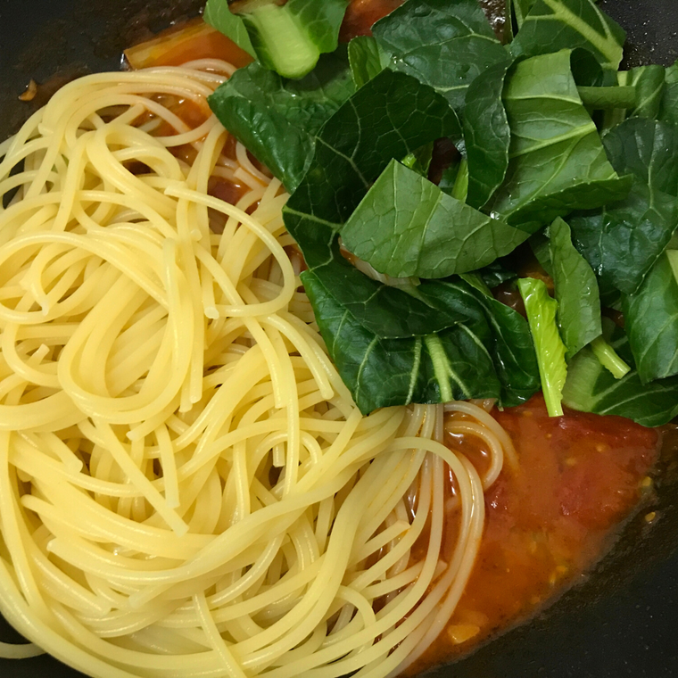 ソースにパスタと小松菜の葉を加える。