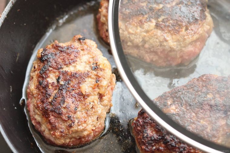 フライパンでハンバーグを蒸し焼きにしている様子