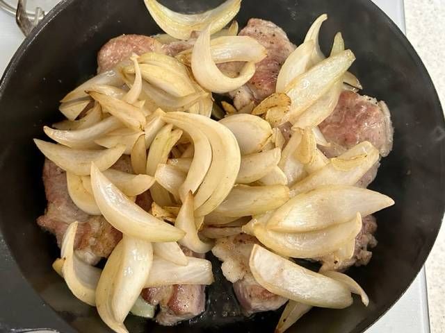 フライパンで炒めている豚ロース肉と玉ねぎ