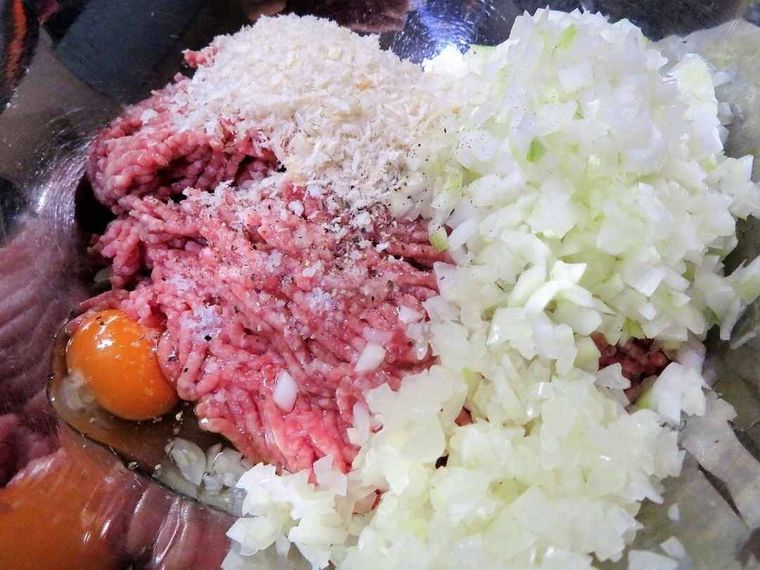 ボウルにひき肉、玉ねぎのみじん切り、キャベツの芯のみじん切り、パン粉、卵、塩こしょうが入っている